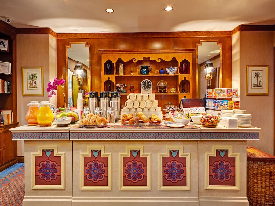 A buffet counter with a variety of food items, a coffee station, and a selection of books and decorative items on shelves.