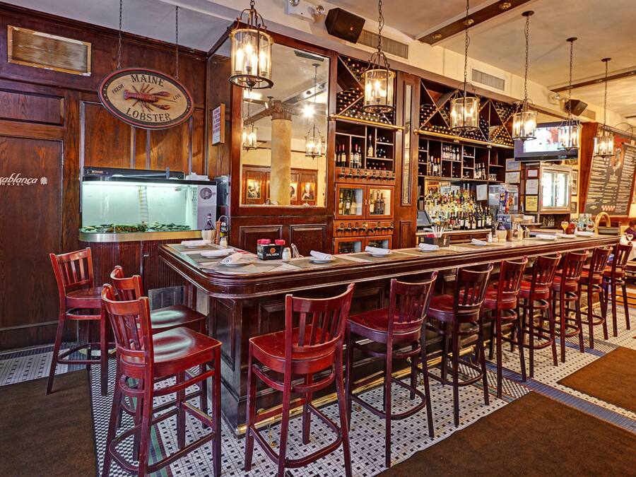 A bar with wooden decor, a lobster sign, and a large mirror.
