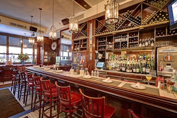 A bar with wooden decor, a lobster sign, and a large mirror. at Casablanca Hotel by Library Hotel Collection