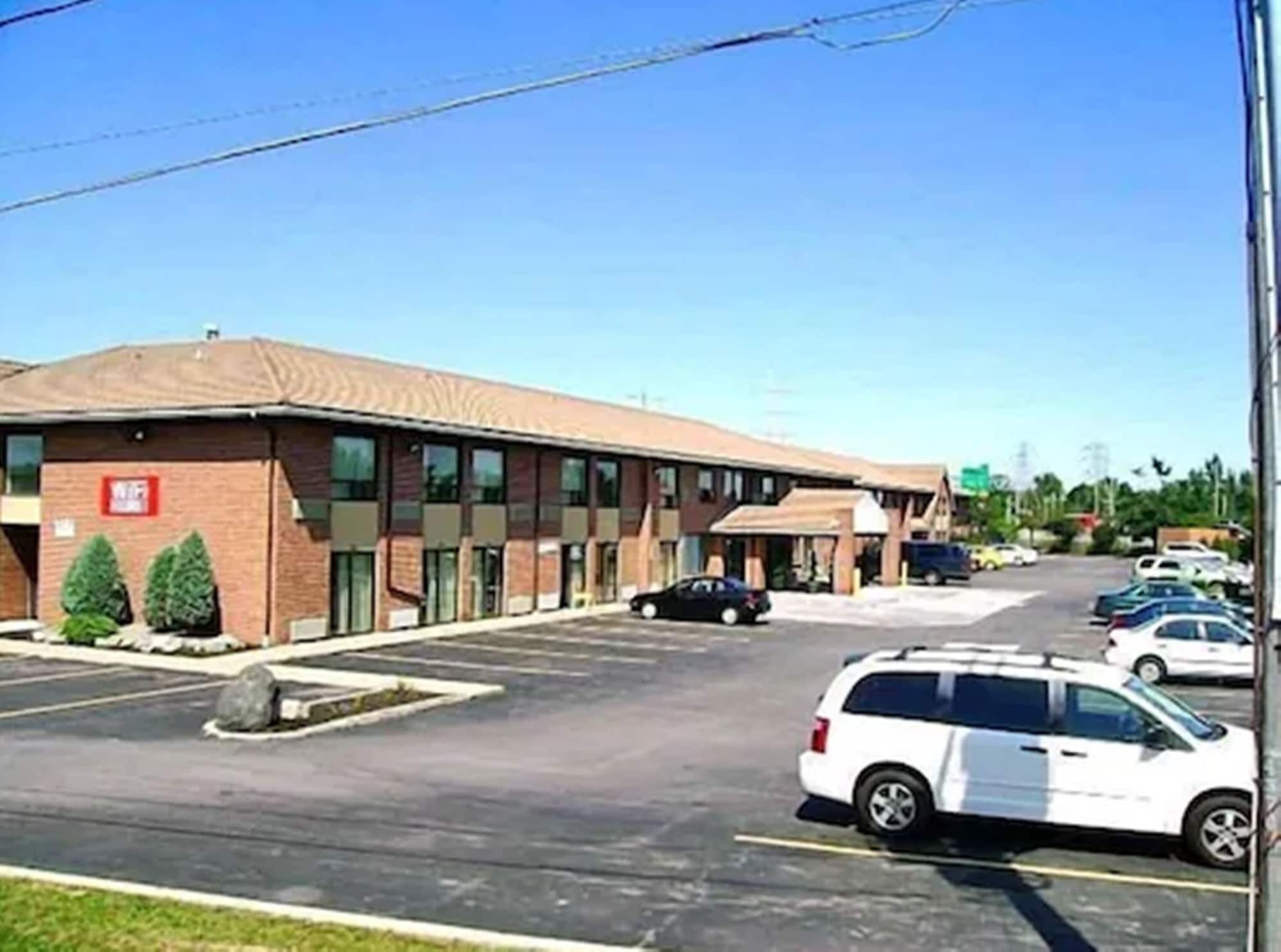 A multi-story building with a parking lot in front.
