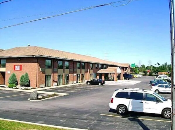 A multi-story building with a parking lot in front.