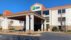 Un bâtiment de l’hôtel Holiday Inn Express doté d’une entrée abritée, de nombreuses fenêtres et surplombant un ciel dégagé.