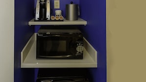A compact kitchenette with a microwave, coffee maker, and a small refrigerator.