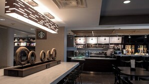 A modern bar area with a counter, seating, and a display of circular wooden objects.