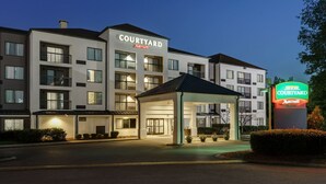 A Courtyard Marriott hotel with a covered entrance, multiple floors, and a well-lit facade.