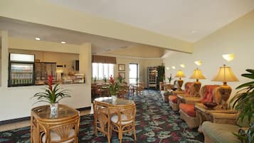 Welcome to our hotel lobby, featuring a spacious reception area with a display case, comfortable seating and wicker furniture.