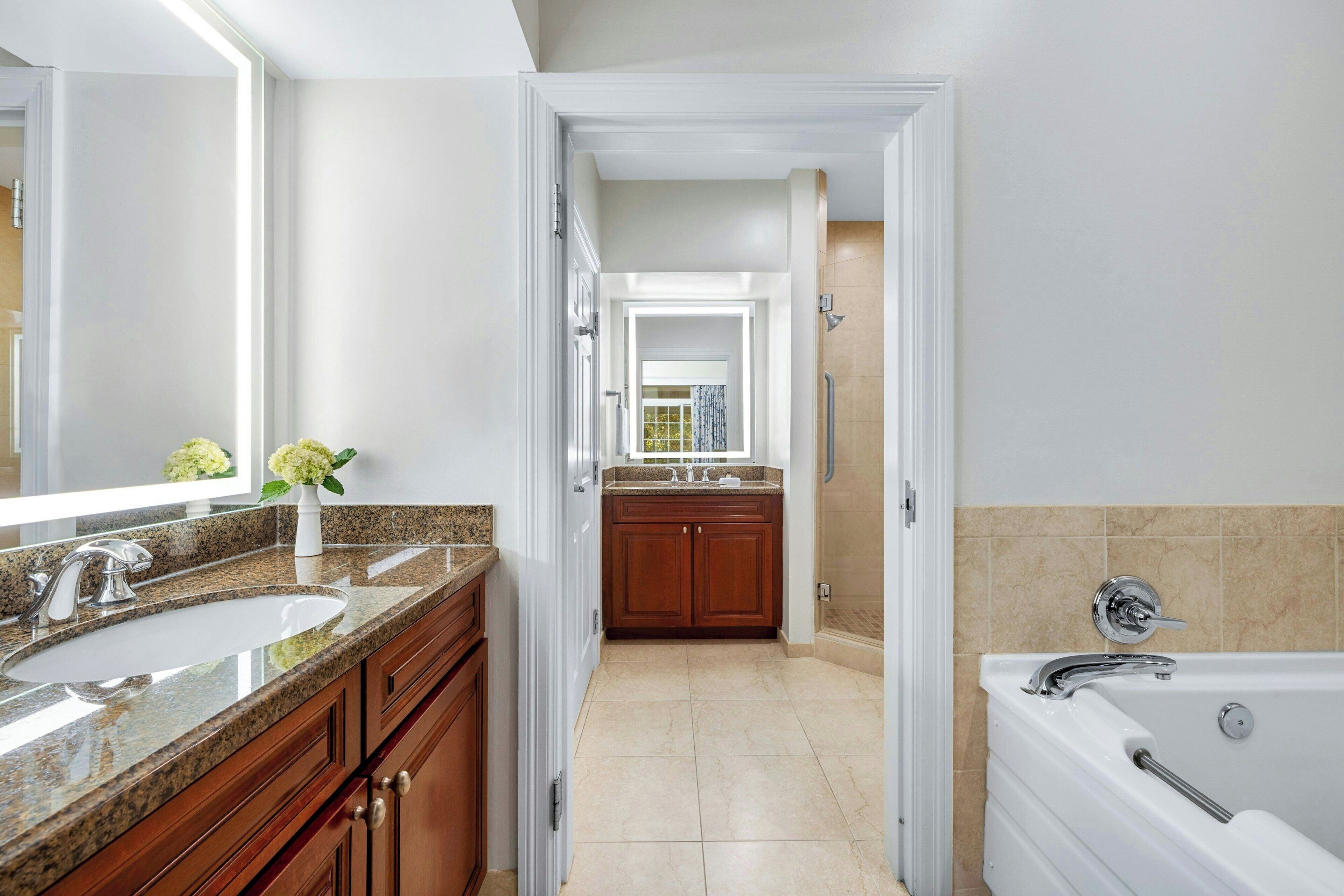 A modern bathroom with a double sink, vanity, and a bathtub.