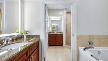 A modern bathroom with a double sink, vanity, and a bathtub.