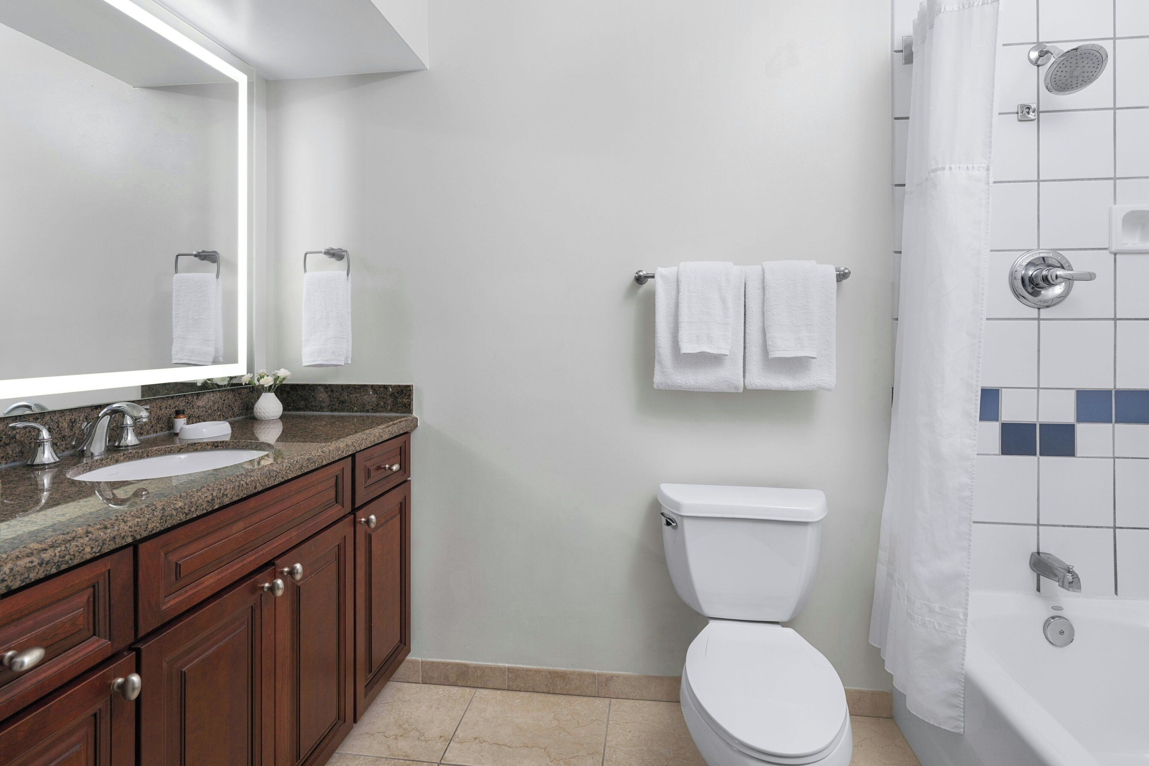 Un baño moderno con dos lavamanos, un inodoro y una bañera.