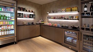 A well-lit bar area with shelves stocked with beverages, snacks, and condiments.