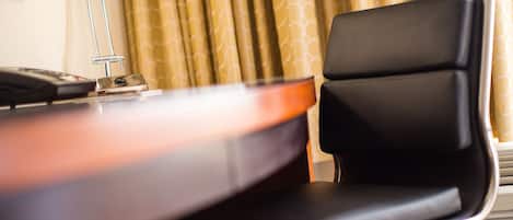 A room with a desk, a chair, and a curtain.
