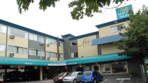 A hotel with a parking lot, a clear entrance, and a sign indicating the Seattle Pacific Hotel. - Seattle Pacific Hotel (Seattle)