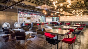 A modern restaurant with high ceilings, exposed beams, and a variety of seating options including tables, chairs, and a bar area. - Red Lion Hotel Kennewick Columbia Center (Kennewick)