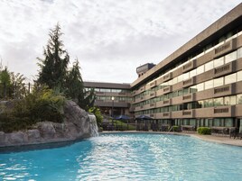 Una piscina al aire libre de temporada, sombrillas
