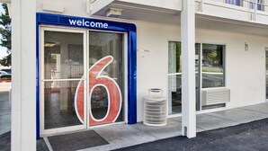 A building entrance with a 'Welcome' sign and a large number '6' on the door.