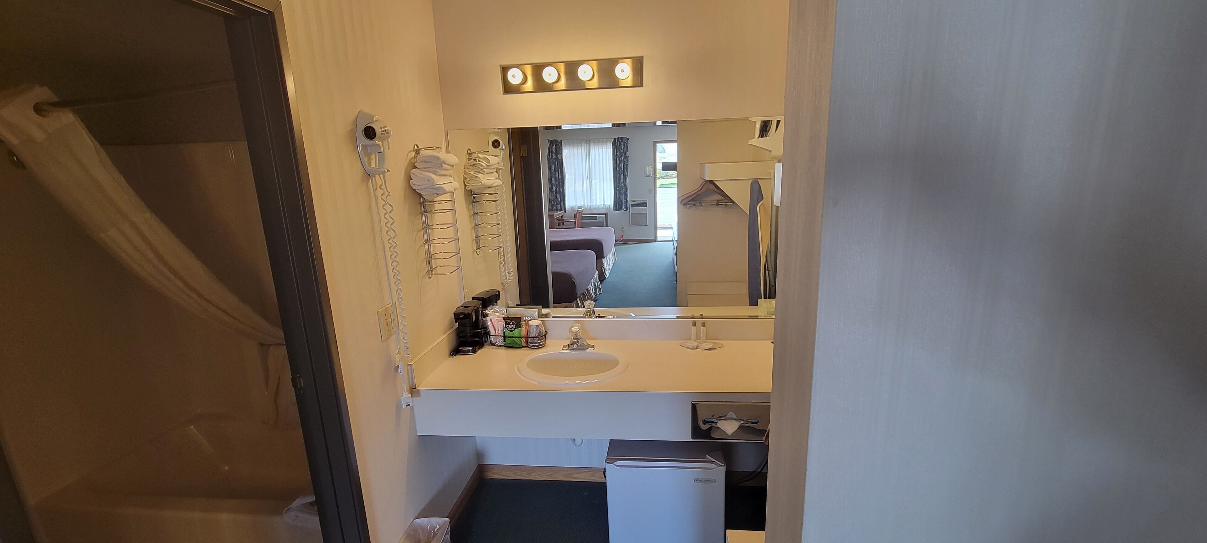 Un baño con lavamanos, espejo y teléfono.