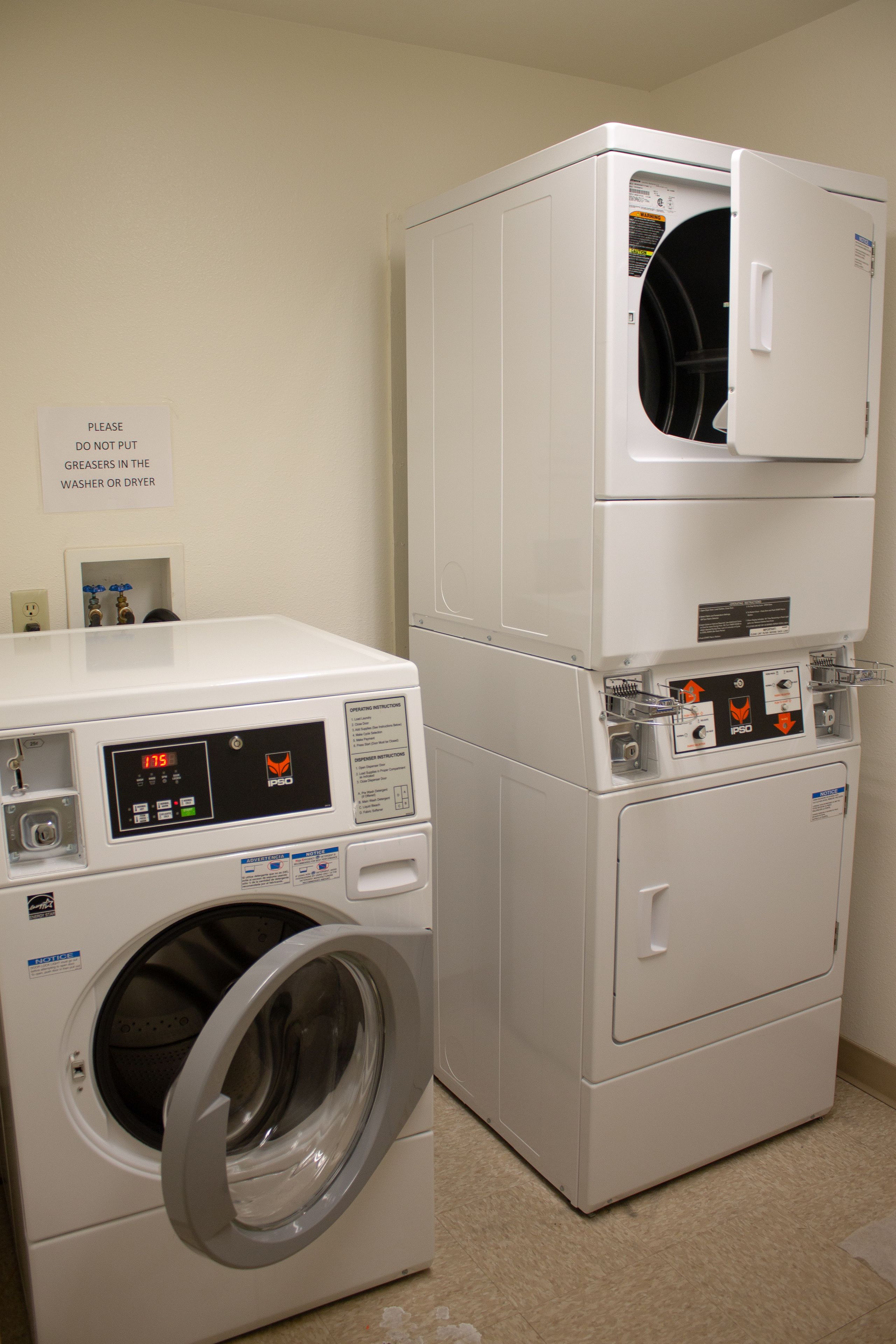 A laundry room with a front-loading washer and a stacked dryer.