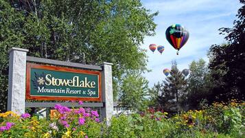 A sign for Stowe Lake Mountain Resort & Spa surrounded by colorful flowers.