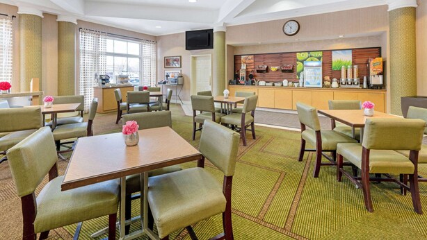 A hotel lobby with multiple seating areas, a reception desk, and a clock on the wall. - La Quinta Inn & Suites by Wyndham Salt Lake City Airport (Salt Lake City)