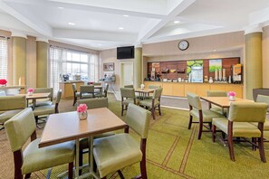 Relax in the inviting lobby, featuring comfortable seating, a reception desk, and artwork on the walls.