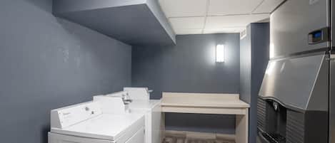 A compact kitchen with a built-in washer and dryer, a refrigerator, and a countertop.