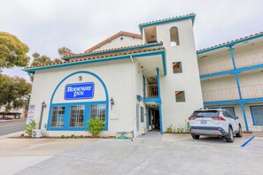 Welcome to the Rodeway Inn, a two-story building with a flat roof, featuring a prominent entrance and a glass door.