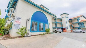 A building with a blue archway and a sign indicating it is a guest parking area. - Hotel Avenida, San Clemente Beach (San Clemente)