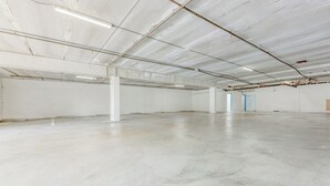 An empty industrial-style interior with exposed ceilings, concrete floors, and minimalistic white walls. - Hotel Avenida, San Clemente Beach (San Clemente)