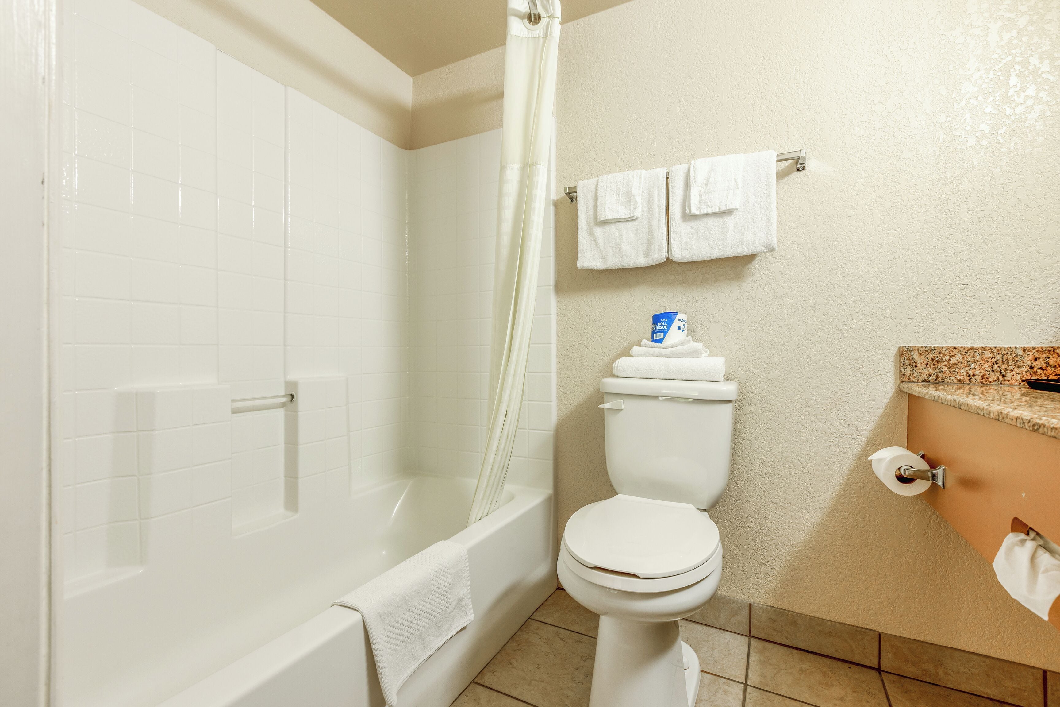 Een badkamer met een bad, toilet en wastafel.