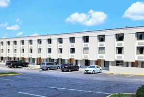 A modern hotel with a row of rooms, a parking lot, and a clear blue sky. - Motel 6 Catonsville, MD – Baltimore West (Catonsville)