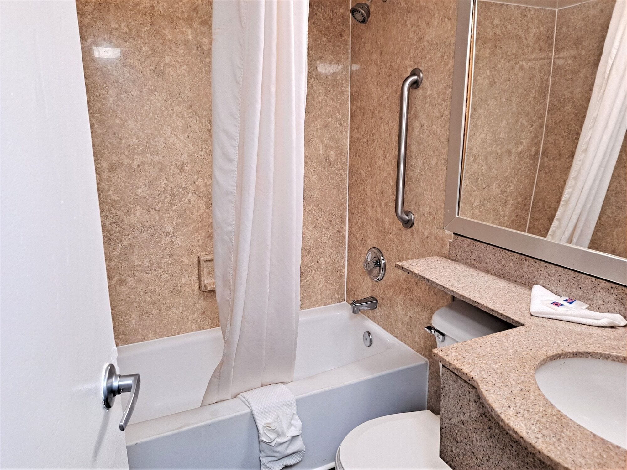 Une salle de bain moderne équipée d’une baignoire, de toilettes, d’un lavabo et d’un miroir.