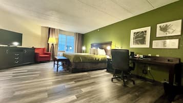 Ein Hotelzimmer mit Bett, Schreibtisch, Stuhl und Fernseher.