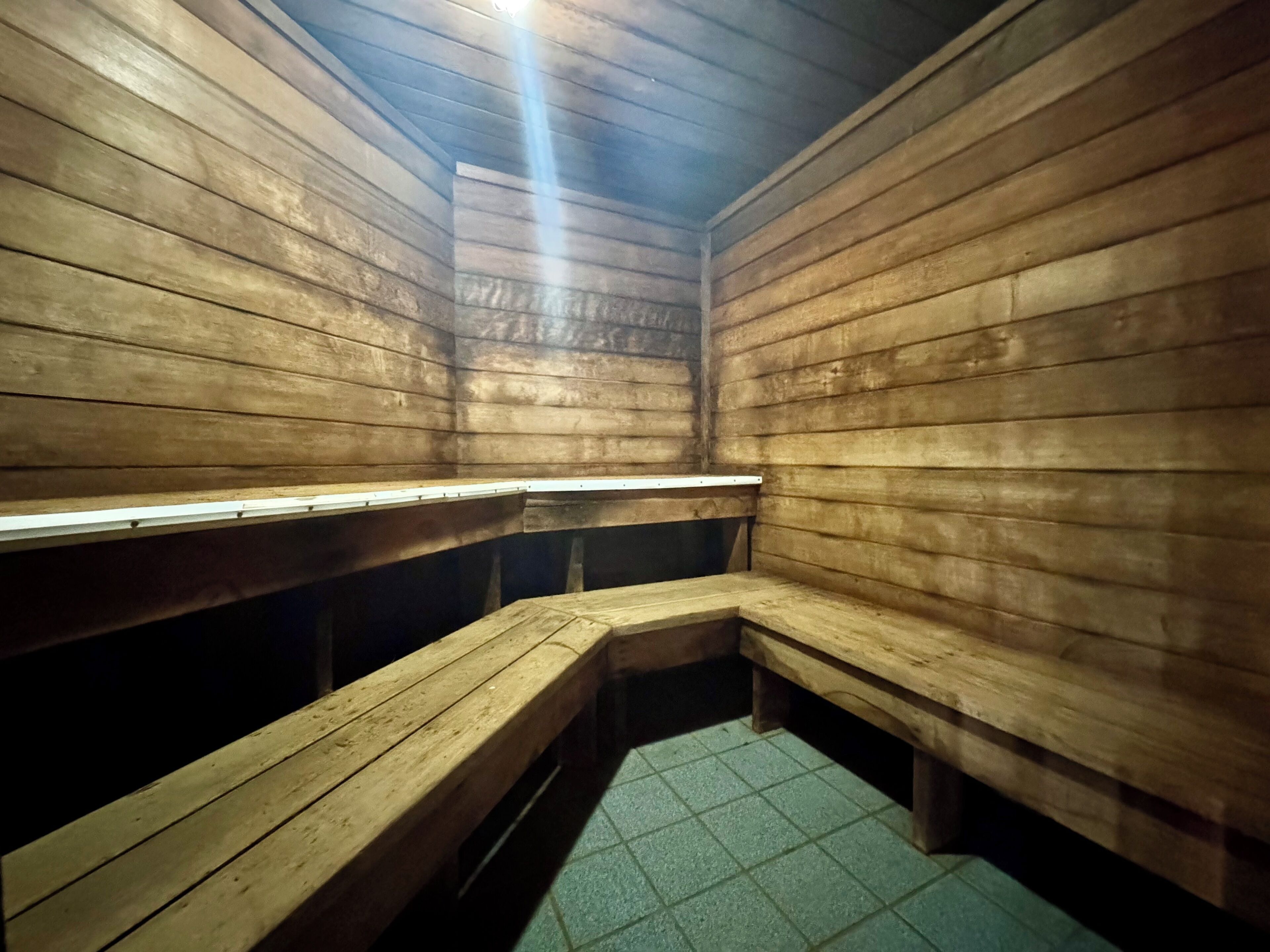 A sauna with wooden benches and a tiled floor.