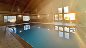 An indoor swimming pool with clear water, wooden beams on the ceiling, and windows with natural light. - Quality Inn & Suites Alexandria (Alexandria)