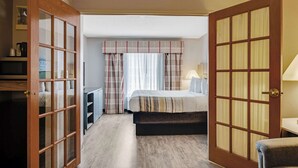 Une chambre d’hôtel avec un lit, un bureau et une chaise.