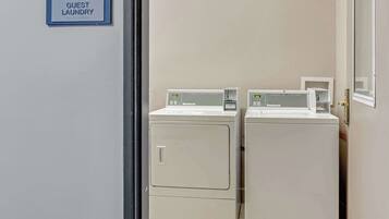 A guest laundry area with two Haebsch brand washing machines and a sign indicating it is for guests.