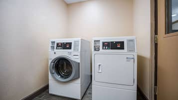 Een wasserette met twee wasmachines en een droger.