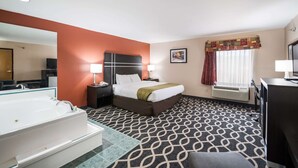 A hotel room with a large bed, a separate bathroom with a bathtub, a desk, and a window with curtains. - Quality Inn Jacksonville near Little Rock Air Force Base (Jacksonville)