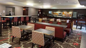 A hotel lobby with seating areas, a bar, and a self-service food station. - Country Inn & Suites by Radisson, Garden City, KS (Garden City)