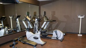 A gym with stationary bikes, a bench, and a mirror. - Country Inn & Suites by Radisson, Garden City, KS (Garden City)