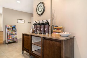 A reception area with a wooden counter, a clock, a bulletin board, and a coffee station. - Country Inn & Suites by Radisson, Frederick, MD (Frederick)