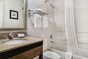 A bathroom with a sink, toilet, and bathtub.