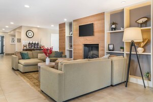 Una sala de estar moderna con un sofá modular, una chimenea y estanterías empotradas.