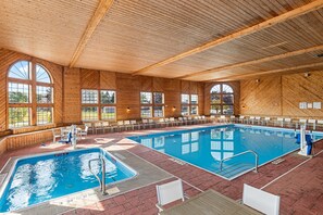 An indoor swimming pool with wooden walls and large arched windows. - Comfort Inn & Suites Ludington near US-10 (Ludington)