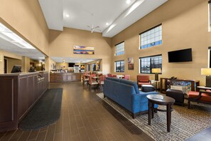 A hotel lobby with a reception desk, seating area, and a bar. - Comfort Inn & Suites Ludington near US-10 (Ludington)