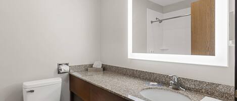 A bathroom with a toilet, sink, and mirror.