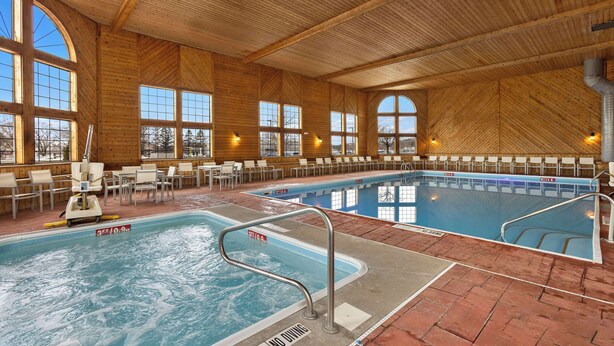 Une piscine intérieure avec des murs en bois et de grandes fenêtres.