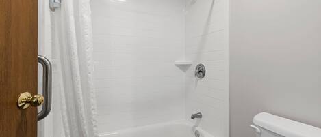 A bathroom with a bathtub, a shower, and a toilet.