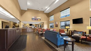 Un hall d’hôtel comprenant un comptoir d’accueil, un espace salon et un coin repas.