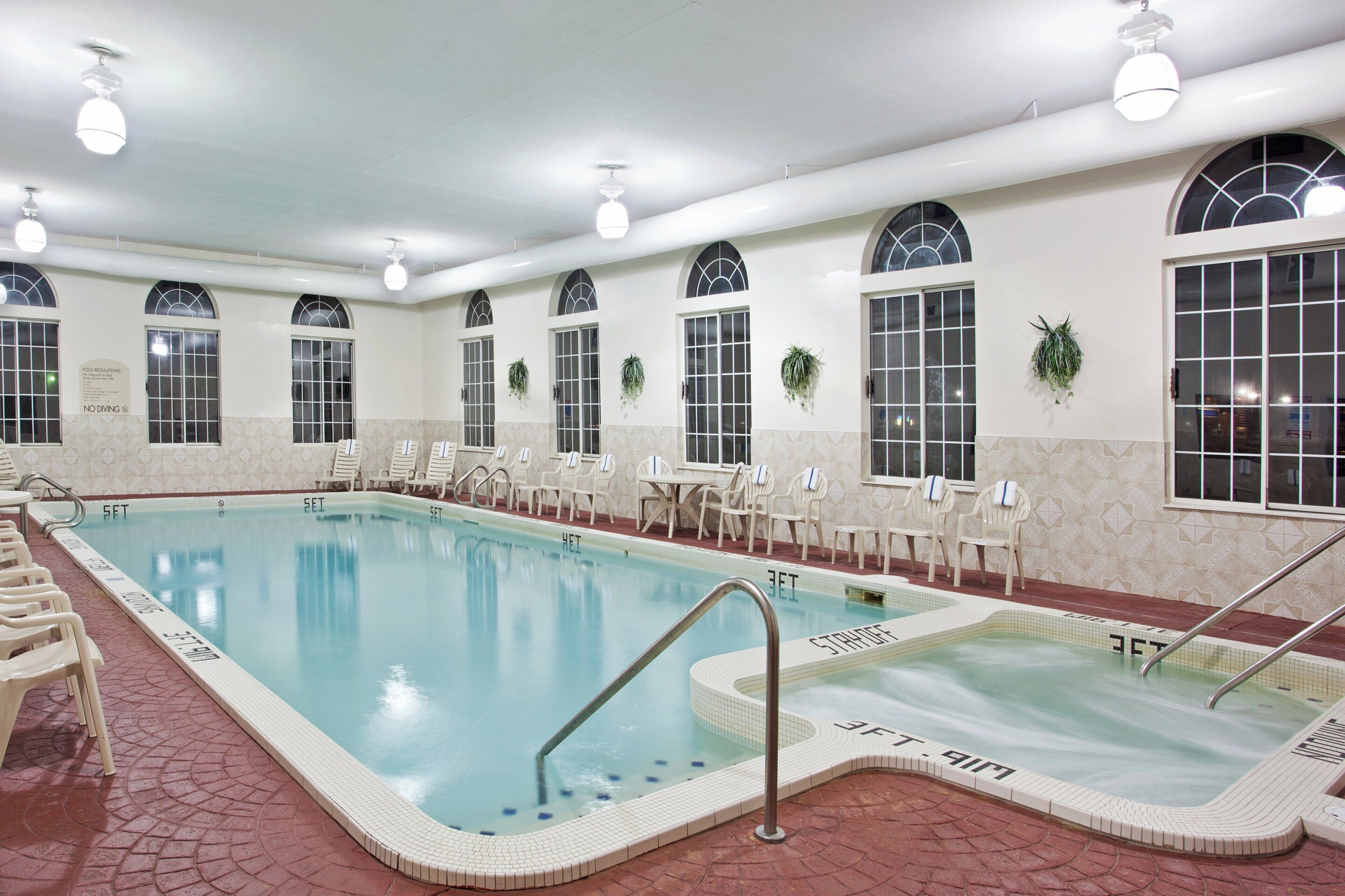 Ein Innenpool mit Whirlpool, Liegestühlen und einem Poolbereich.